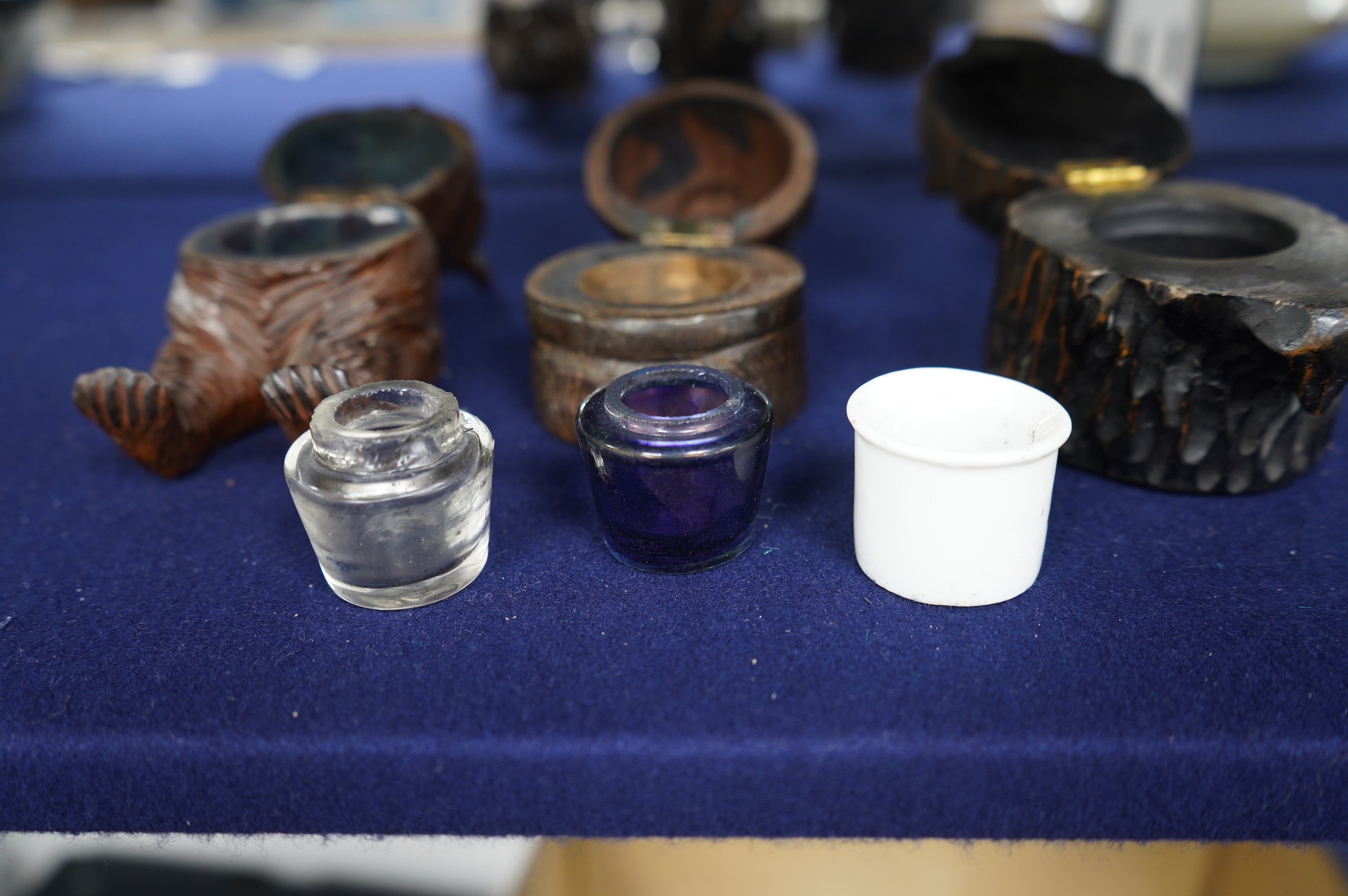 Three Black Forest carved wood novelty inkwells with glass and ceramic liners, one in the form of a lion, largest 9cm high. Condition - fair